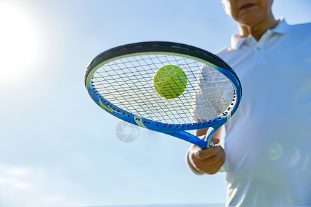 男性运动老年男性手握网球拍特写背景