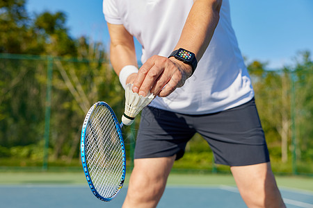 体育老年男性羽毛球运动发球特写背景