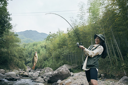 青年女性溪流钓鱼图片