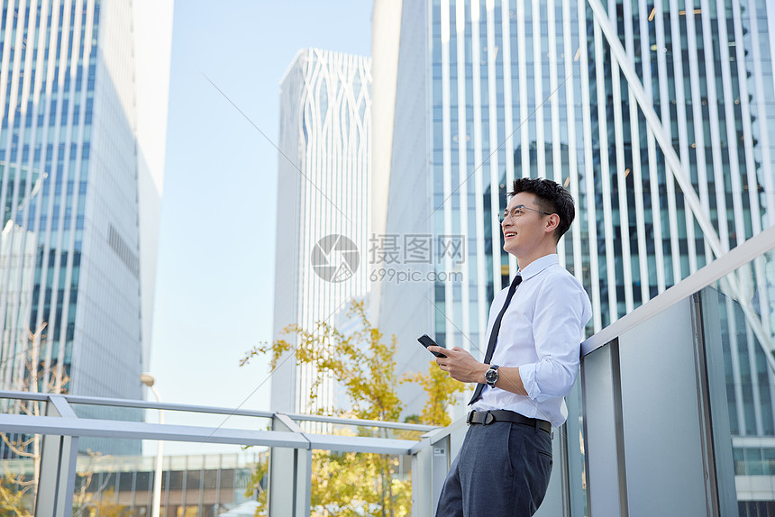 户外玩手机的商务男士形象图片