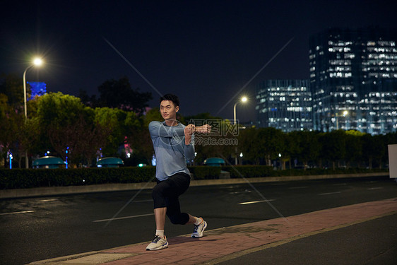 男青年夜晚运动拉伸形象图片