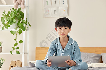 居家玩平板电脑的小男孩背景图片