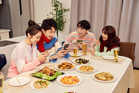 团聚年轻人餐桌上使用手机抢红包背景