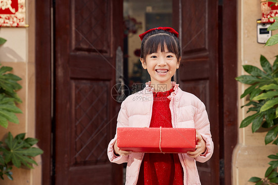 站在门口手捧礼物的小女孩图片