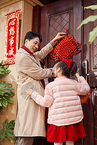 爸爸和女儿在门口装饰中国结图片