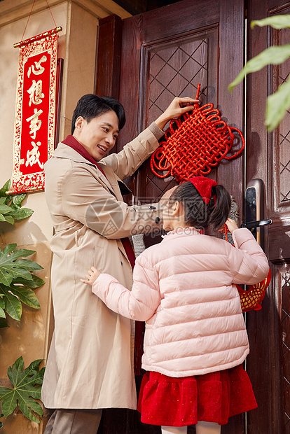 爸爸和女儿在门口装饰中国结图片