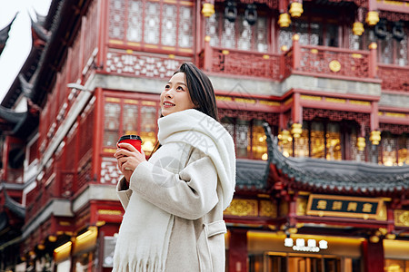 手捧咖啡的女子感受节日氛围图片