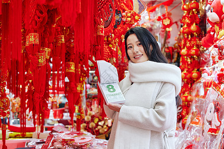 青年女性手拿新年日历展示背景图片