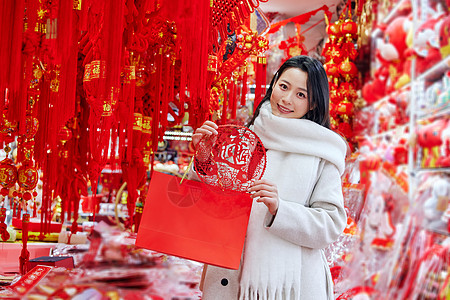 女人味儿年货店里挑选窗花的青年女性背景