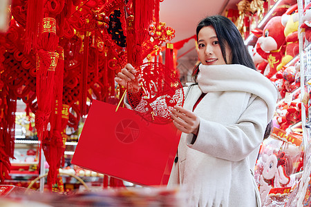 在年货店里挑选窗花的女子图片