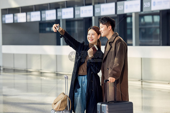 在机场准备出发旅行的情侣自拍图片