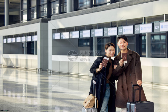 在机场准备出发旅行的情侣手拿护照图片