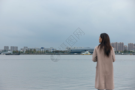 年轻美女站在江边背影图片