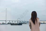 文艺年轻美女站在江边背影图片