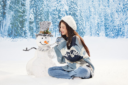 甜美冬日女孩与雪人玩偶互动图片