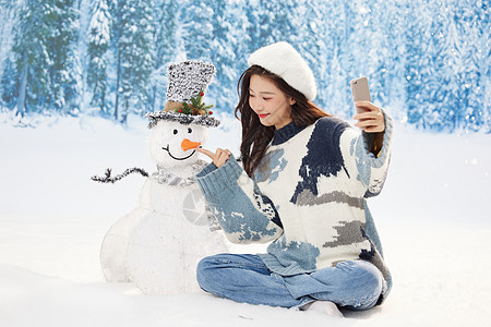 冬日甜美女孩与雪人互动自拍图片