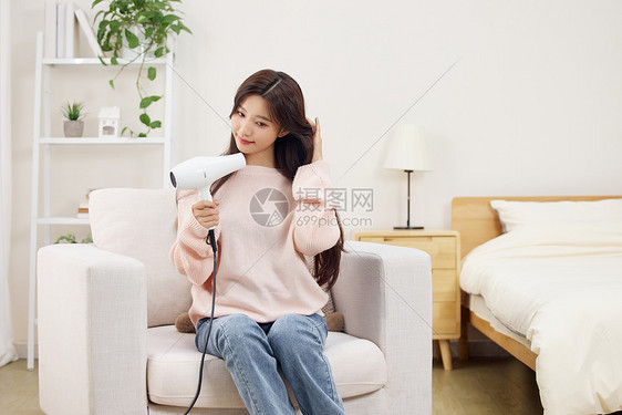 冬日居家女性使用吹风机吹头发图片