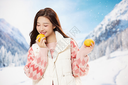 冬日手捧橘子的青年美女图片