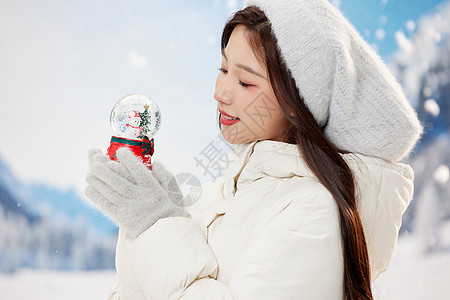 甜美冬季女性手拿圣诞水晶球图片