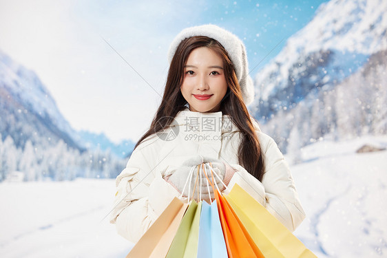 雪地甜美冬季美女手拿购物袋图片