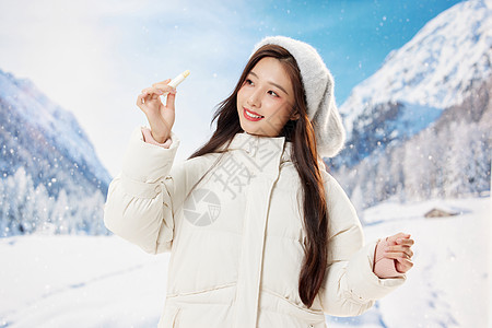 青年女孩雪地里使用唇膏图片