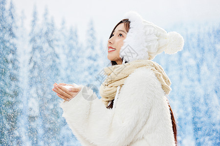 雪地里捧雪花的青年女性图片