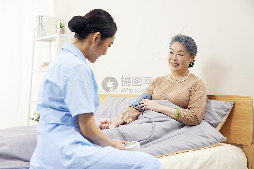 护工帮老年患者测量血压图片