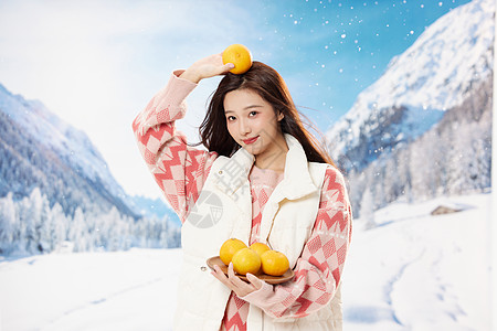 手捧橘子的冬日女性形象背景图片