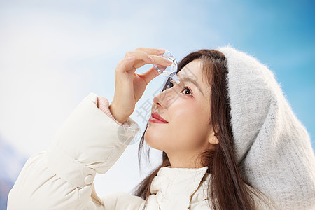 青年女孩雪地里使用眼药水图片