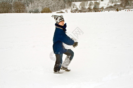 孩子手里拿着一个大雪球给雪人图片