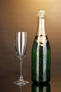 棕色背景中的一瓶香槟和高脚杯图片