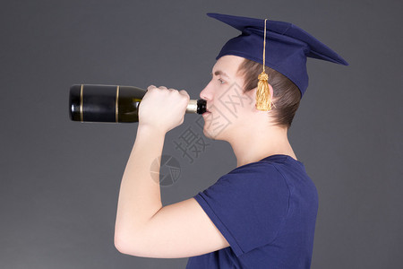 毕业男子在灰色背景下喝香图片