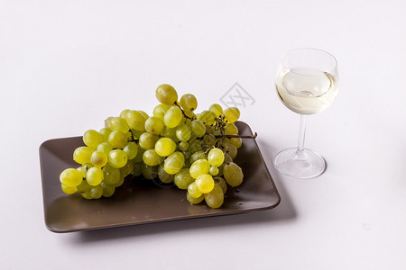 白葡萄与一杯白葡萄酒在白色背景图片