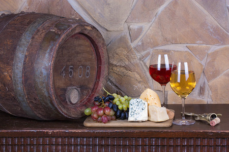 葡萄酒窖玻璃杯和一瓶葡萄酒用铁环在旧背景