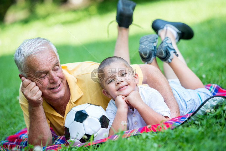 快乐的祖父和孩子玩得开心在阳光明媚的日图片