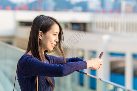 在街上使用智能手机的快乐女人图片