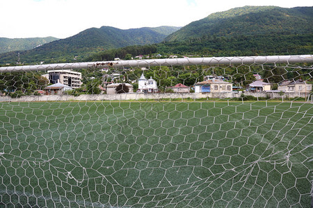 在山区体育场用网子足球和足球背景图片