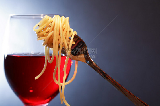 意大利传统晚宴面食和面粉叉在黑暗背景的图片
