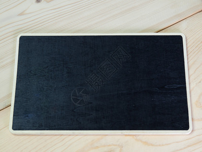黑板框放在棕色的木板上背景图片