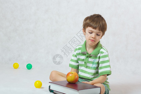 一个六岁的男孩观察书本不快背景图片