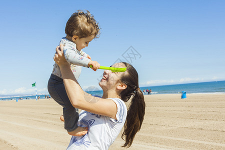 青少年和她的弟在海滩玩耍在阳光明媚的图片