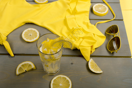 黄色泳衣单件飞行员太阳镜和柠檬汁图片