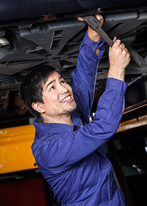 快乐的男机械师在汽车修理店举起的图片