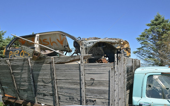 有木箱的老卡车装满了一辆残骸的汽车图片