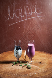蓝莓的奶昔木制桌上的两杯玻璃果汁图片