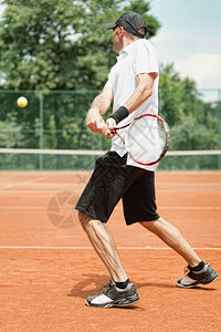 网球运动员在泥土法庭上用双手反图片