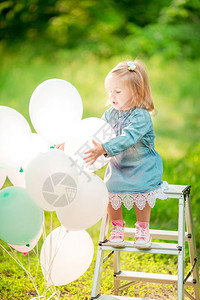 公园里拿着气球的快乐小女孩图片