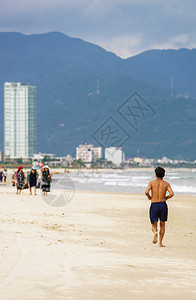 男子在越南岘港的海滩跑步它也被称为NonNuoc海滩背景是南图片