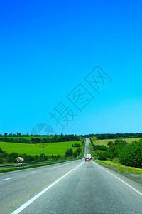 柏油路边有绿色的田野蓝天图片