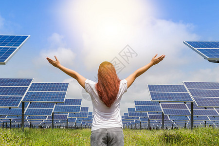 亚洲妇女站起来举起双臂成就功并庆祝光伏太阳能农场站的成图片